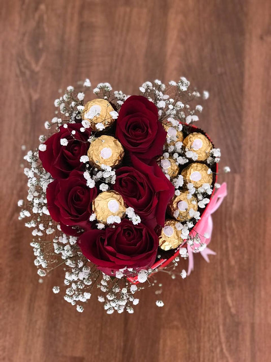 Caja de rosas rojas con chocolates en forma de corazón